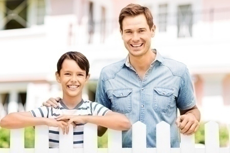 Father And Son Standing Behind Fence