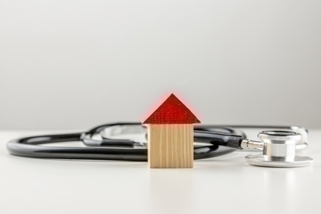 Stethoscope with a wooden model of a house
