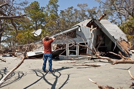 man grieving over destroyed house