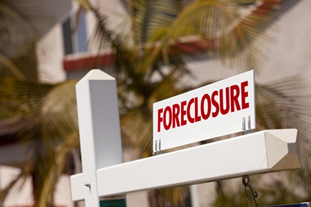 Close-up Foreclosure Real Estate Sign in Front of House.
