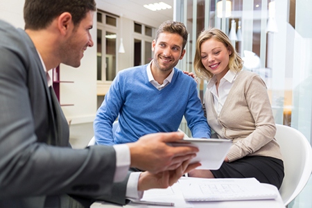 Young couple meeting real-estate showing a house project on a di