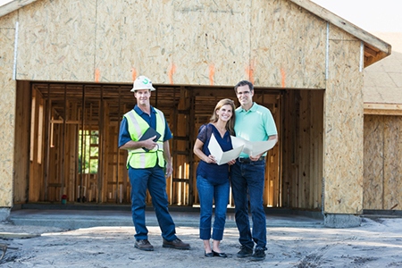 Builder and couple at new home under construction