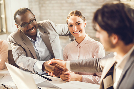 Happy business people shaking hands in the office.