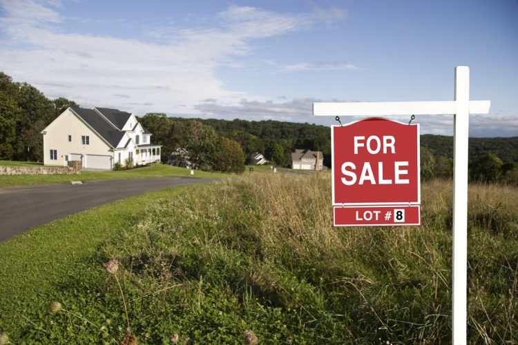 Real Estate sign showing land is for sale in a new subdivision.
