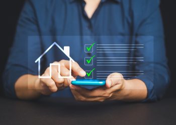 Male hand interacts with smart home checklist on mobile phone screen, symbolizing modern home automation, digital management, and residential technology in real time.