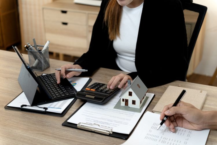 Professional Asian woman adult man collaboratively analyze financial data purchase agreement office desk. Real estate planning investment property acquisition mortgage calculation business strategy