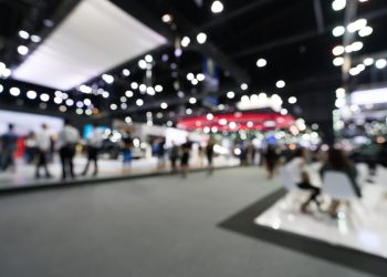 Blurred, defocused background of public event exhibition hall. Business trade show or commercial activity concept