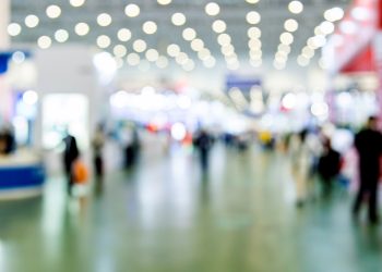 Abstract defocused crowd of people walking in exhibition.